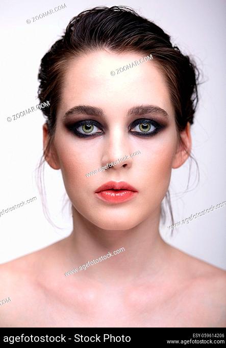 Closeup macro portrait of female face. Woman with unusual evening beauty face makeup . Girl with perfect skin, green pistachio colour eyes and violet - black...