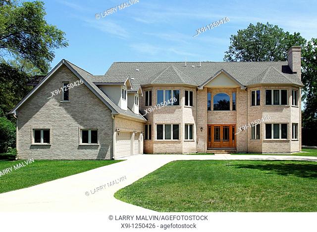 Large brick home in suburbs with three car garage