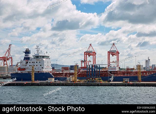 Dublin, Ireland - June 6, 2017: Large industrial cranes loading container ship in Dublin Port in Ireland