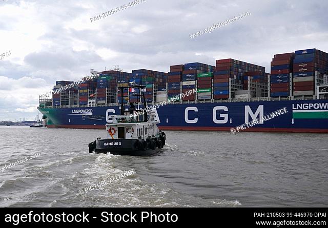03 May 2021, Hamburg: The huge container ship ""CMA CGM Jacques Saade"" of the shipping company CMA CGM sails on the Elbe past the Teufelsbrück jetty towards...