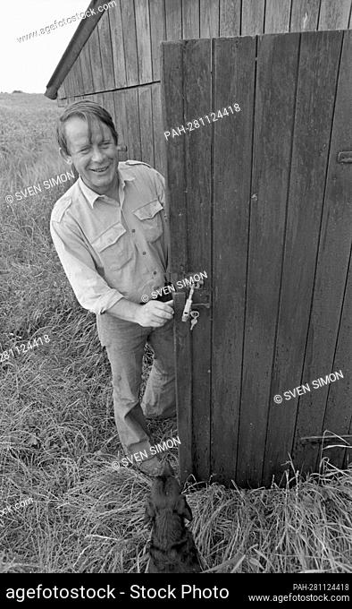 Culture/literature The writer Siegfried LENZ, stands in front of a barn, at a stable door, in the foreground a dog, Lebollykke, 01.07.1973