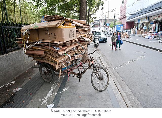 three-wheeled bike for picking waste paper and cardboards on street in Shanghai, China