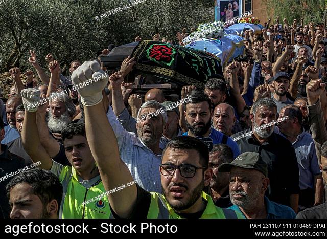 07 November 2023, Lebanon, Blida: Lebanese mourners raise their fists the funeral procession of three sisters, killed along with their grandmother in an Israeli...