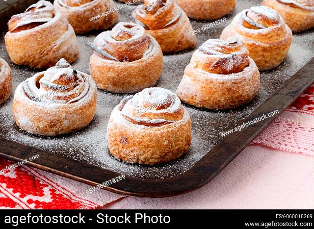 Fresh baked cinnamon rolls on steel baking tray. Homemade cinnamon buns for breakfast