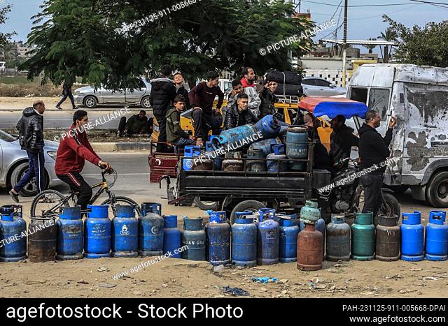 25 November 2023, Palestinian Territories, Khan Yunis: Palestinians queue to refill their liquid gas cylinders, on the second day of a four-day cease fire...