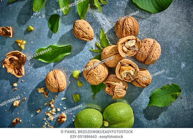 Walnuts and leaves on gray background