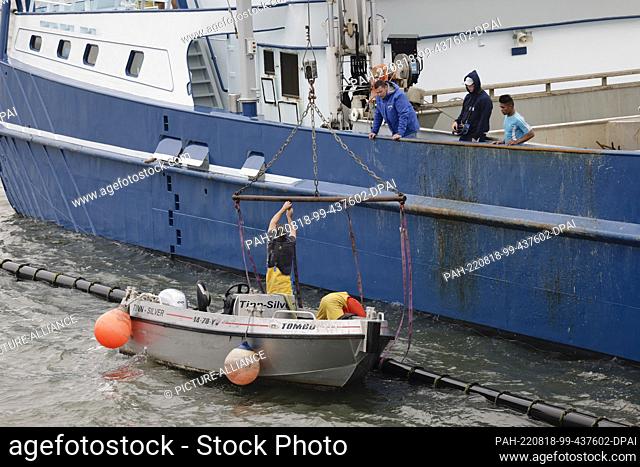 18 August 2022, Schleswig-Holstein, Hörnum (Sylt): Crew members of a mussel fishing cutter work on a seed mussel harvesting unit