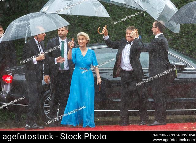 25 July 2023, Bavaria, Bayreuth: Ursula von der Leyen (CDU), President of the EU Commission, and husband Heiko (l) arrive in the rain for the opening of the...