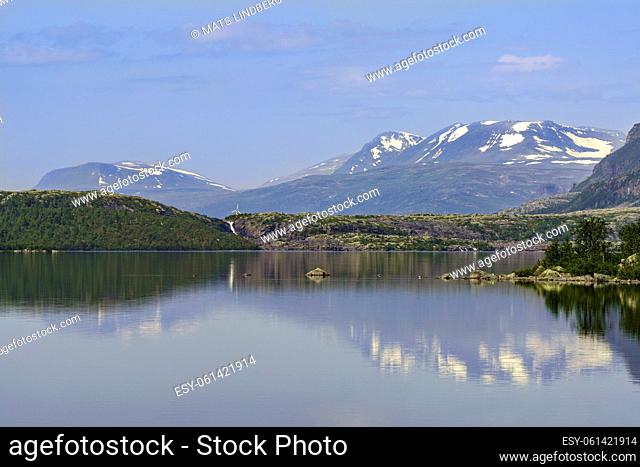 Stor sjöfallet national park in summer time with nice sunny weather, mountain reflecting in Lule river, still snow on top of the mountains