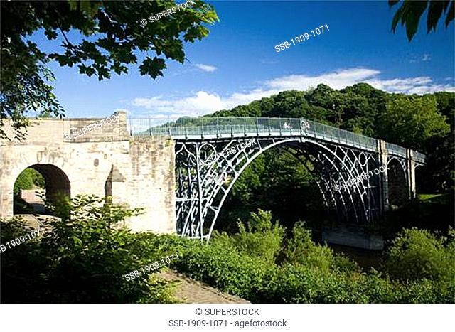 The worlds first iron bridge spans the banks of the River Severn in late evening summer light Ironbridge Shropshire England United Kingdom GB Great Britain...