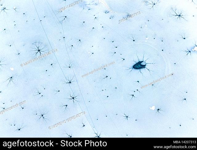 Italy, province of Belluno, Auronzo di Cadore, Dolomites, aerial view on the lake of Santa Caterina, iced surface with graphic signs on the ice