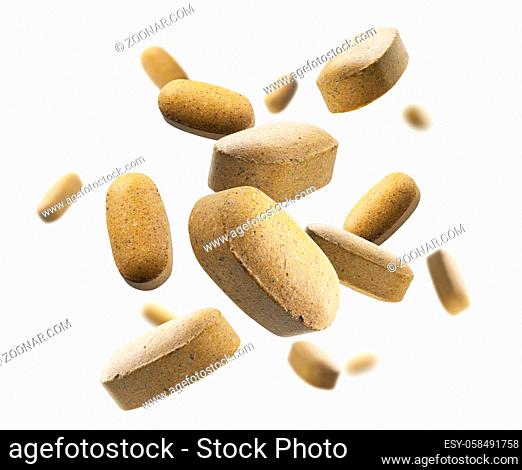 Yellow tablets levitate on a white background