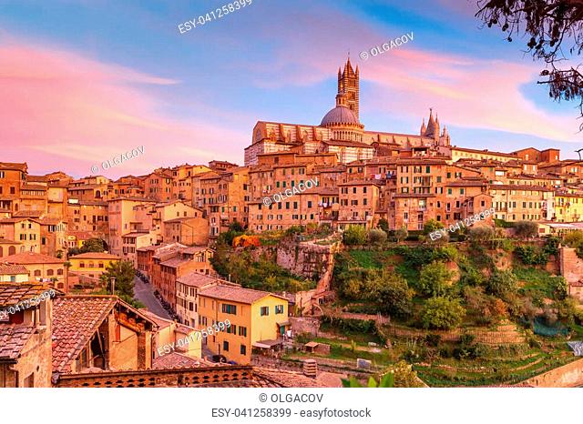 Beautiful view of Dome and campanile of Siena Cathedral, Duomo di Siena, and Old Town of medieval city of Siena at gorgeous sunset, Tuscany, Italy
