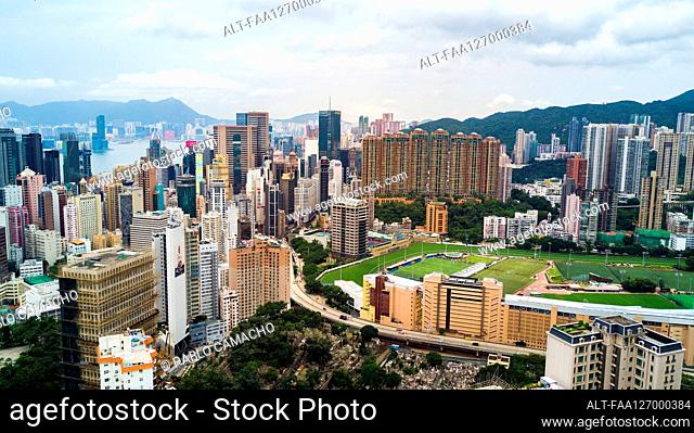 View of modern cityscape with stadium near Victoria Harbour in Hong Kong