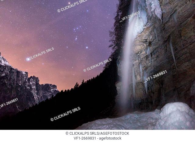 The cascade of hell (Cascata dell'Inferno)at the end of the valley of San Lucano, Taibon Agordino. Photographed in the winter under a starry sky with the...