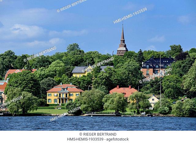 Sweden, Stockholm, Djurgarden, seaside villas and the Hallestad belfry in the open air museum Skansen in the background