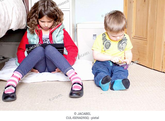 Children using digital tablet and cellular phone