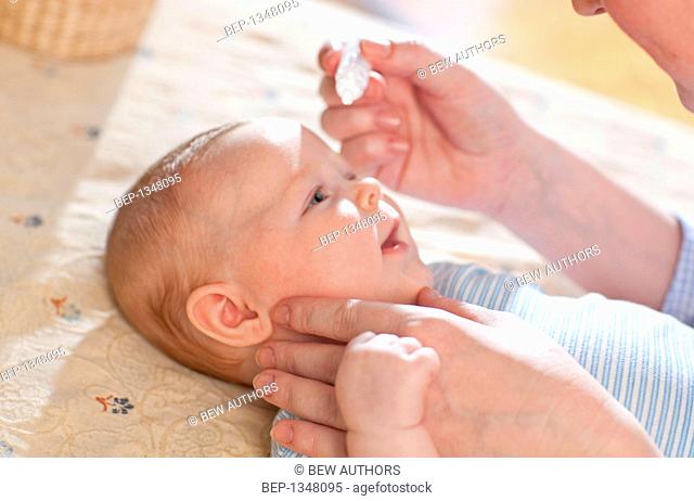 Mother dosing up her baby with eyedrops