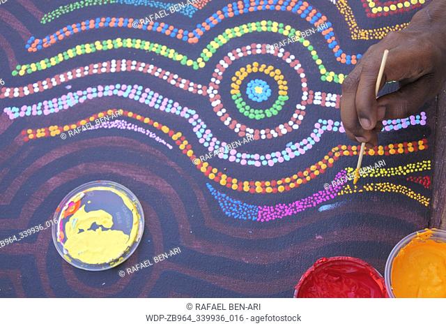 DERBY, WA - SEP 10 2019:Aboriginal artist dot painting.Before Indigenous Australian art was ever put onto canvas the Aboriginal people would smooth over the...