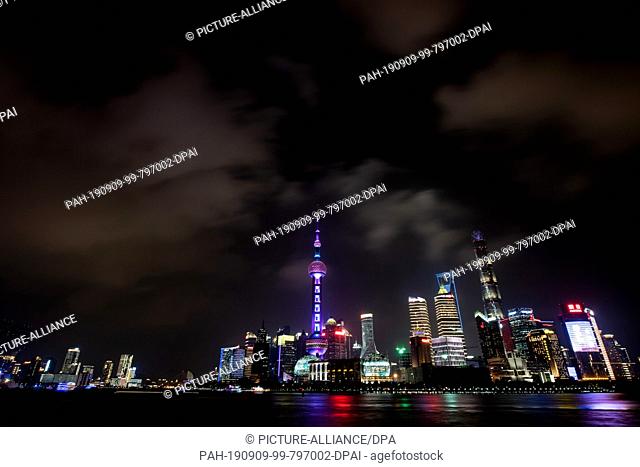 08 September 2019, China, Shanghai: View from the promenade ""The Bund"" at the Huangpu river to the illuminated skyline of the special economic zone Pudong...