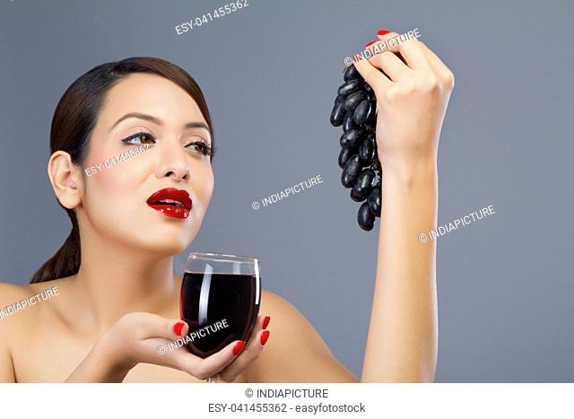 Woman holding a glass of wine and grapes