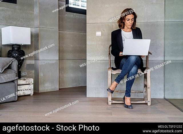 Businesswoman working on laptop while sitting on chair at office