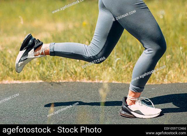 Runner woman in running shoes closeup of woman sporty legs. Female jogging