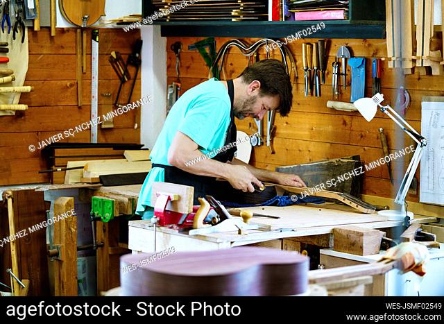 Craftsperson standing by workbench working in workshop