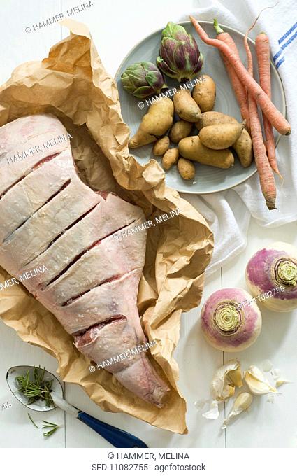 Lamb with Slits Cut on Butchers Paper and Assorted Vegetables For Roasting, From Above