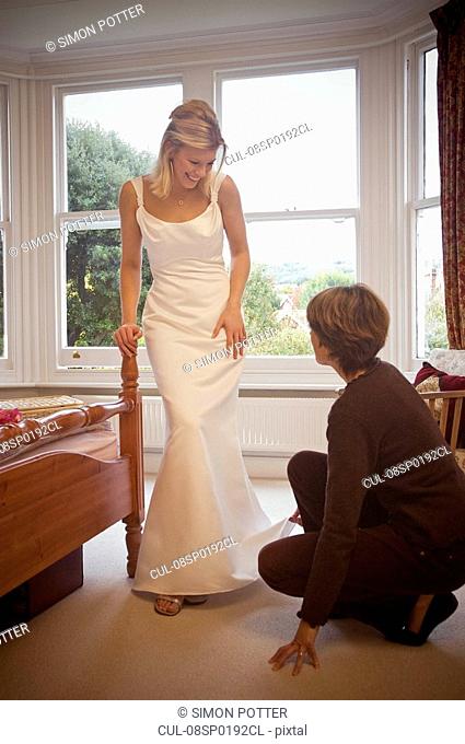 A bride having her dress fitted