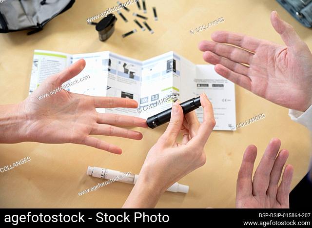 Close-up of a woman's hands and a doctor's hands explaining how to measure her blood sugar and treat her diabetes
