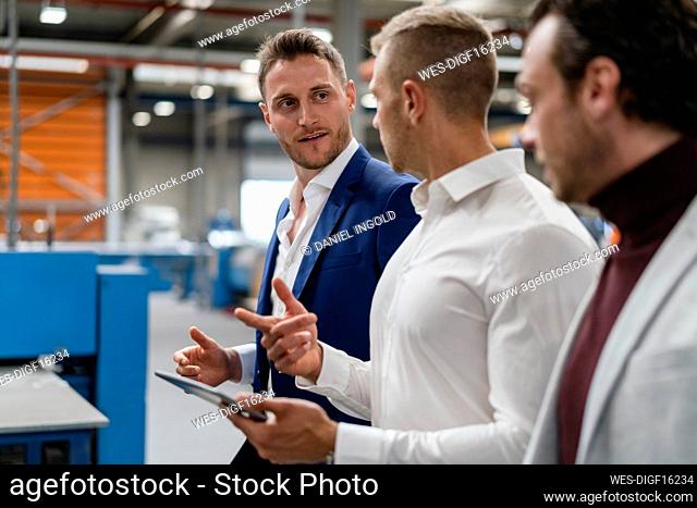 Male professionals discussing while working at industry