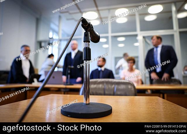 15 August 2022, Schleswig-Holstein, Kiel: A microphone stands on a table in front of the bench with the joint plaintiffs and their lawyers at the start of the...