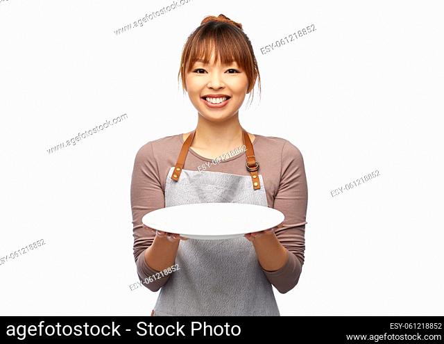 happy woman in apron with empty plate