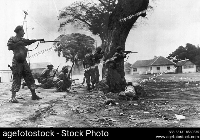Dutch Flush Snipers in Burning City -- Taking shelter behind a tree, Dutch soldiers, members of petrol entering burning east Java city of Malang, Aug