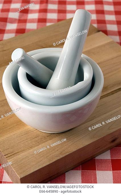 2 mortars and pestles on cutting board, on red checkered table cloth