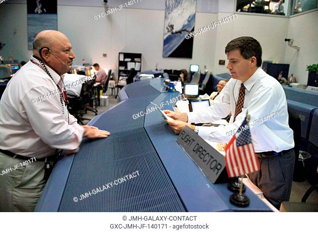 Karl Silverman (left), with the Space Flight Meteorology Group, talks with Flight Director Steve Stich in the Shuttle (White) Flight Control Room on landing day...