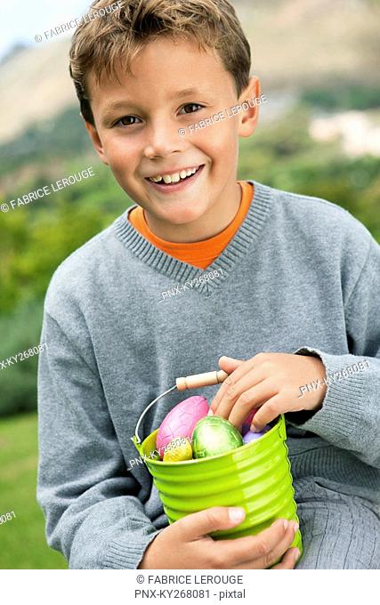 Boy holding a container full of Easter eggs