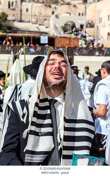 The young guy in tallit prays