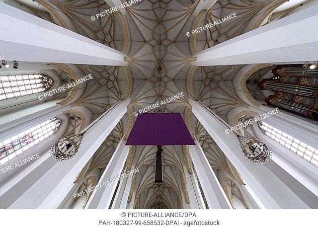 27 March 2018, Germany, Munich: A purple cloth covering the cross in front of the altar in the Munich Frauenkirche. Representations of Jesus are covered in many...