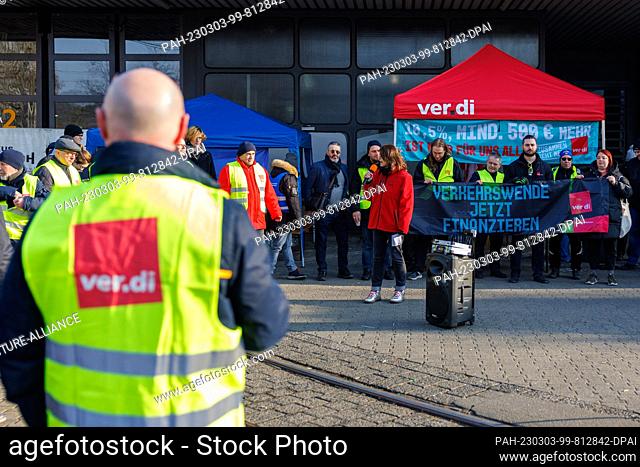 03 March 2023, Mainz: Strikers stand with a banner in front of the depot in Mainz. The trade union Verdi plans to paralyze public transport in numerous cities...