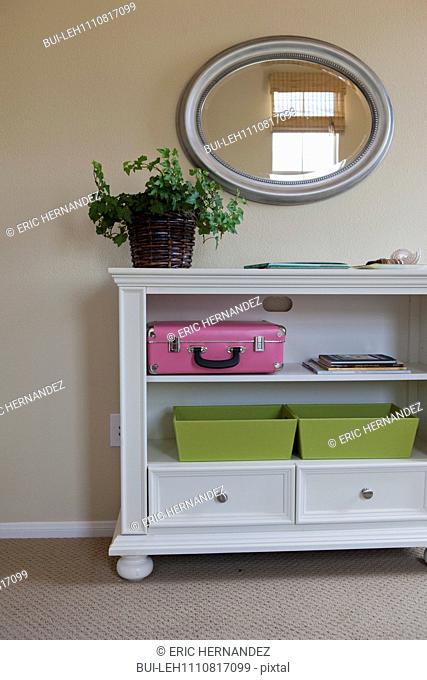 End table with suitcase and drawers in shelves at home