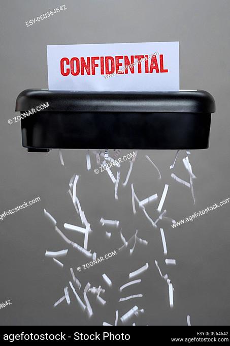 A shredder destroying a document - Confidential
