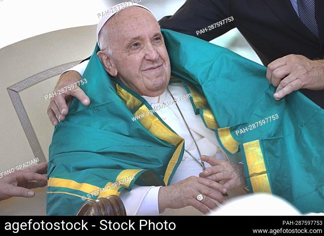 An Indian priest covers the shoulders of Pope Francis with a green shawl, a symbol of respect and honor.Pope Francis during a weekly general audience at Saint...