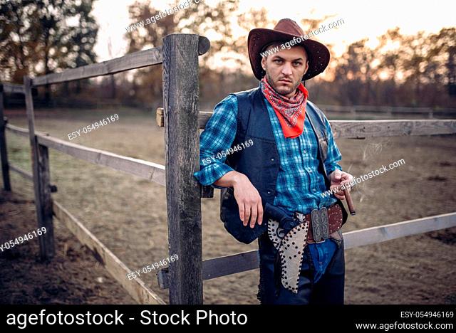 Brutal cowboy poses in the horse corral, texas ranch, western. Vintage male person on farm, wild west lifestyle