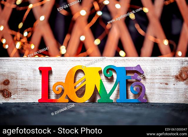 Bright christmas or valentines day background with garland and rainbow colored word love
