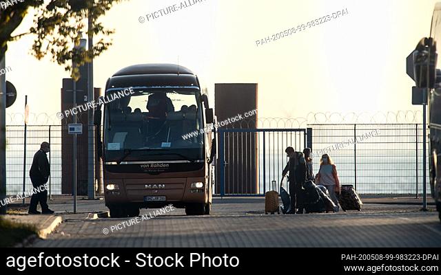 08 May 2020, Lower Saxony, Cuxhaven: Crew members of the cruise ship ""Mein Schiff 3"" board buses in the early morning at the terminal in front of the cruise...