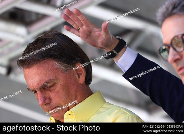 12 October 2022, Brazil, Belo Horizonte: Jair Bolsonaro (l), president of Brazil who is running for re-election, is blessed in front of supporters during an...