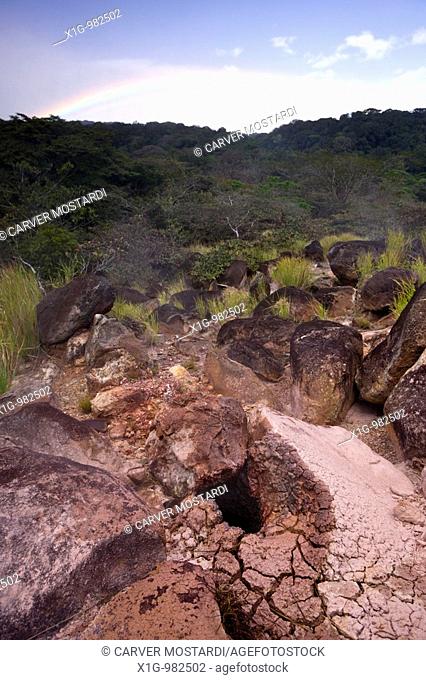 Thermal mud pot with rainbow in the background at Parque Nacional Volcano Rinc—n de la Vieja in Guanacaste, Costa Rica