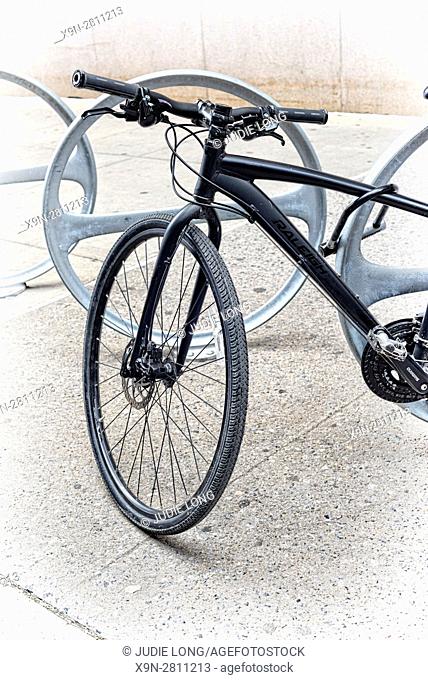Black Racing Type Bicycle Locked to a Bike Parking Station on a Manhattan, New York City Sidewalk